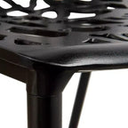 LeisureMod Devon Ensemble de salle à manger d'extérieur 5 pièces - Table ronde en verre avec 4 chaises empilables noires à motif floral